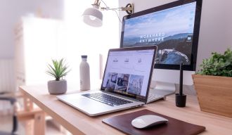 un ordinateur portable, un écran et des plantes sur une table