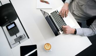 une personne utilisant un ordinateur portable sur une table blanche