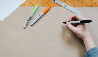 une personne tenant un marqueur noir