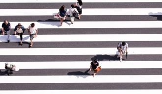 des personnes vues d'en haut en train de marcher sur un passage piéton