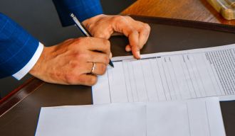 un homme signant des documents