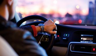 un homme portant une montre conduisant une voiture