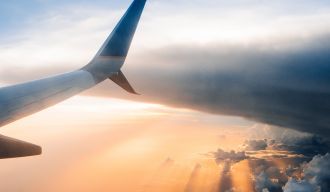 Soleil couchant prit d'un hublot d'avion duquel on voit l'aile