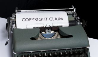 une machine à écrire avec une feuille de papier qui en sort sur laquelle il est écrit "copyright claim"