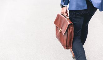 un homme en costume avec un porte-documents en train de marcher