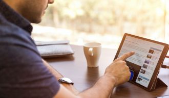 un homme utilisant sa tablette pour surfer sur internet