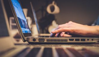 une personne tapant au clavier de son pc portable